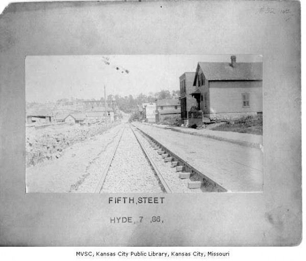 View down 5th Street from Troost Avenue. Heim Brewing sign and Manhattan Clothing Co. sign in view. Street car tracks in foreground. Missouri Valley Special Collections, Kansas City Public Library, Kansas City, Missouri